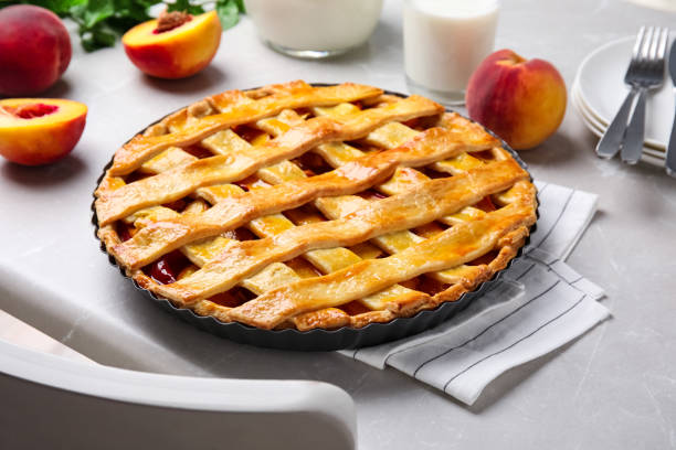 istock Delicious peach pie and fresh fruits on light kitchen table 1362398454