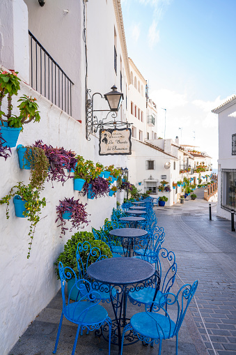 Mijas village blue chairs in Costa del Sol  Mediterranean whitewashed with flower pots in Malaga of Andalusia Spain. Mijas village is one of the best whitewashed villages preserved in the Costa del Sol area of Malaga, located at the top of the mountain. Humans did live here since Bronze Age. Century II was a roman village. In century VIII became Islamic. In 1845 the Catholic kings restored Spain's property until today.