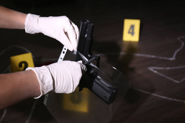 detective putting gun into plastic bag at crime scene, closeup - crime scene chalk outline crime murder imagens e fotografias de stock