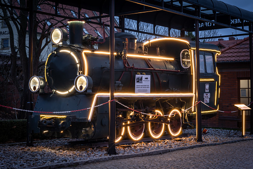 Zamek Topacz, Poland - January 01, 2022: A black vintage locomotive decorated with Christmas lights LED illuminations.