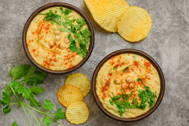 istock Classic hummus with parsley close-up, chips, top view 1362402357