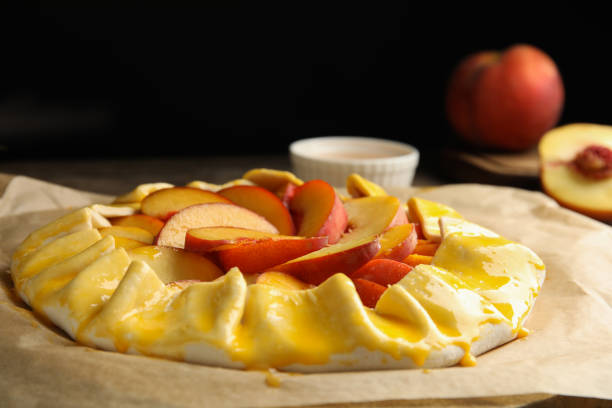 istock Uncooked peach pie on wooden table, closeup 1362402959