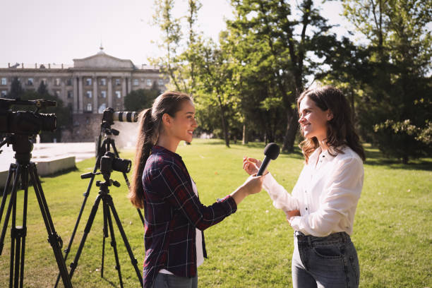 istock Professional journalist taking interview in front of video cameras 1362404594