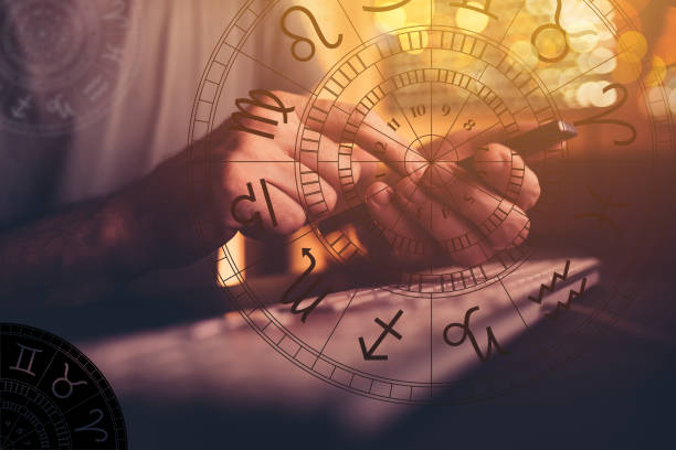 Astrologer using mobile smart phone app and computer to make predictions on future outcome stock photo