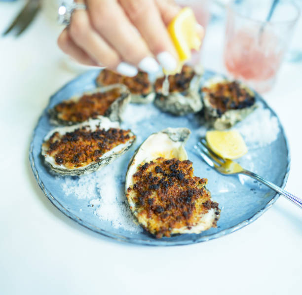 istock Putting a dash of lemon over baked oysters 1362405753