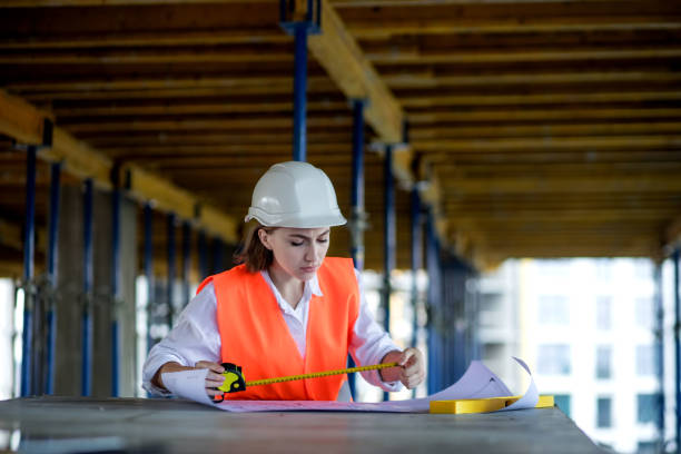 istock Architect or engineer working, browsing building project indoor of construction site with blueprint plan. Woman construction engineers or architects working people 1362405994