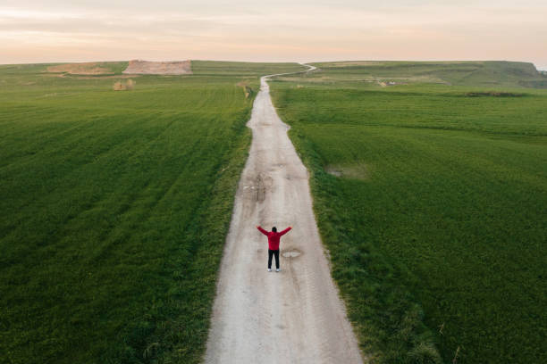 istock Man with arms raised on a dirt road 1362424039