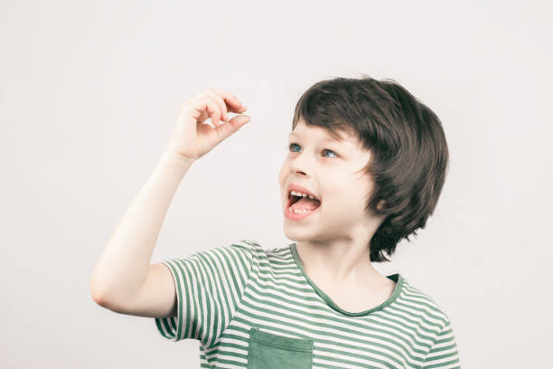 istock Young boy looking at his first lost milk tooth 1362428171