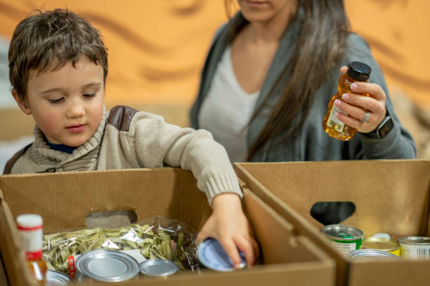 istock Little Boy Packing Food Donations 1362428192