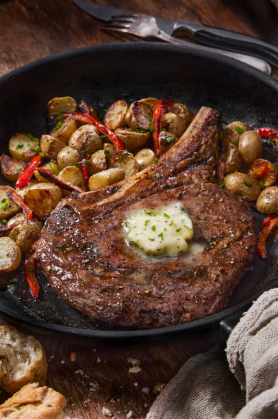 Pan Seared Rib Eye Steak with Roasted Potatoes Pan Seared Rib Eye Steak with Roasted Potatoes, Red Peppers and a Garlic Herb Butter rib eye steak stock pictures, royalty-free photos & images