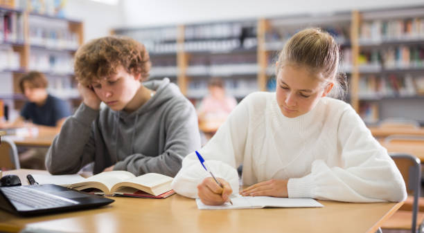istock Girl and boy preparing for exams in library 1362431417