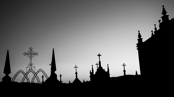 Silhouettes of crosses in a night cemetery. Black and white photo.