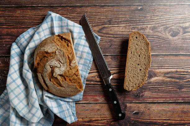 istock A round loaf of a crusty bread, on a rustic wooden table. 1362435939