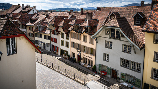 Aarau, Switzerland - April 11, 2021 - A cobbled street with the row of old houses with tiled roofs in the old city Aarau - the capital of the canton of Aargau