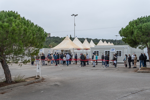 Palma de Mallorca, Spain; january 02 2022: Covid-19 vaccination point at the antique Son Dureta hospital in Palma de Mallorca. People with mask queuing for vaccination. New normality concept