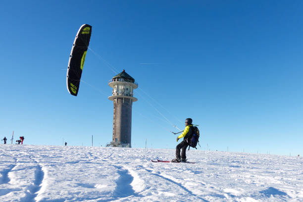 sportivo invernale sulla neve. snow kiter con zaino sugli sci davanti al cielo azzurro. torre di feldberg in una soleggiata giornata invernale nella foresta nera. - black forest forest sky blue foto e immagini stock