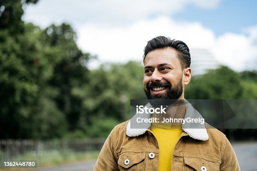 istock Candid portrait of early 30s Indian man standing outdoors 1362448780