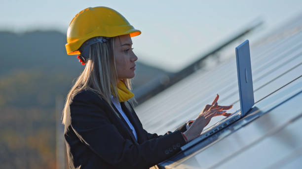 Female engineer working in solar power plant. Renewable energy systems. Solar city.