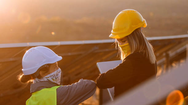 istock Female engineers working in solar power plant. Teamwork during COVID-19. Renewable energy systems. Solar city. 1362449187
