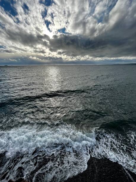 Blue sky tries to break through clouds as the winds push the waves to the shoreline in almost mirrored reflection
