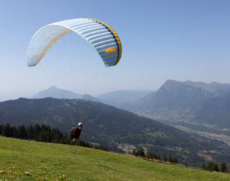 A paraglider taking off from the mountains above Samoens in the French Alps.