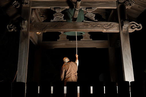A monk ringing a bell to celebrate the new year