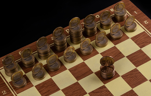 American coins of 1 dollar and Kazakh coins of 100 tenge in the form of chess finures on a chessboard