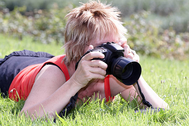 istock Mature woman Photographer lying on grass 136247102