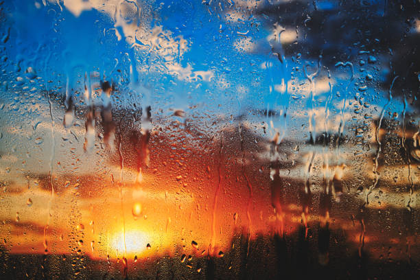istock Bright summer sunset behind dripping glass after rain. 1362473839