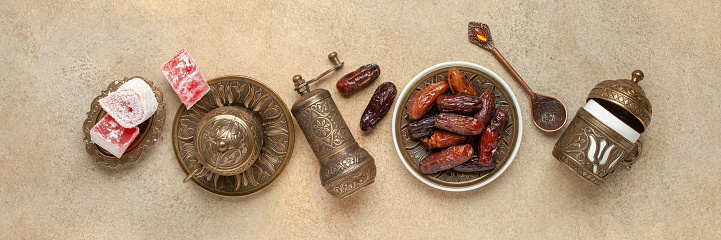 Dried dates and coffee on a dark background.Arabic traditional dishes, pots and dates fruits. Ramadan Kareem, Eid mubarak concept. Top view. Flat lay. Copy space