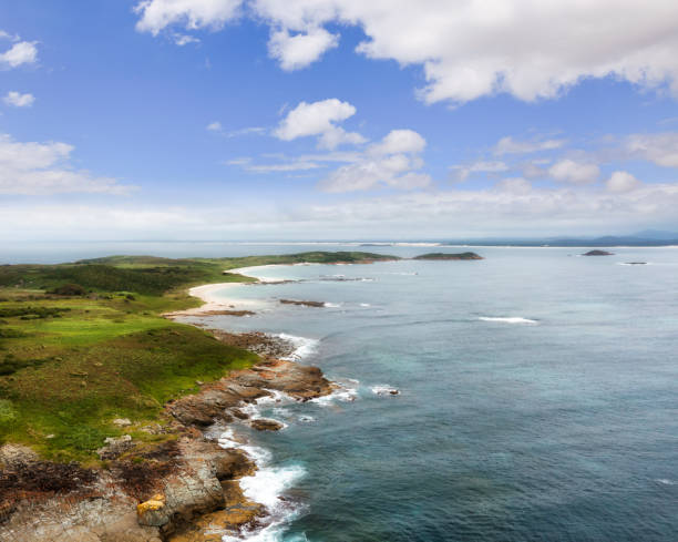 Rugged coastline of Broughton island on Australian pacific shore in aerial seascape towards land.