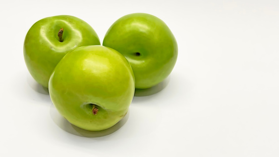 Close up green plums on white background