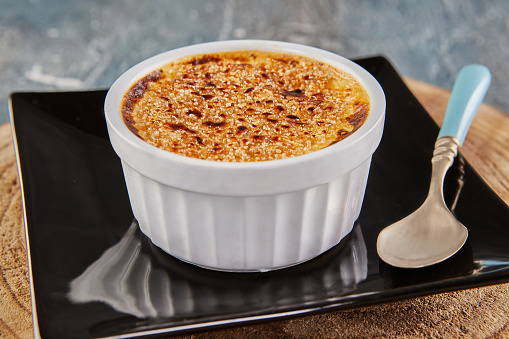 Creme brulee with mushrooms in special form on plate with spoon. French gourmet cuisine.