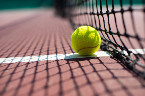 tennis ball lying on the court. healthy lifestyle concept - ténis desporto com raqueta imagens e fotografias de stock