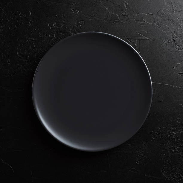 istock Empty round black plate on dark moody black background with copy space. 1362488687