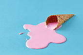 istock Pink ice cream melting and spilling from the waffle cone. Minimalistic summer food concept. 1362489449