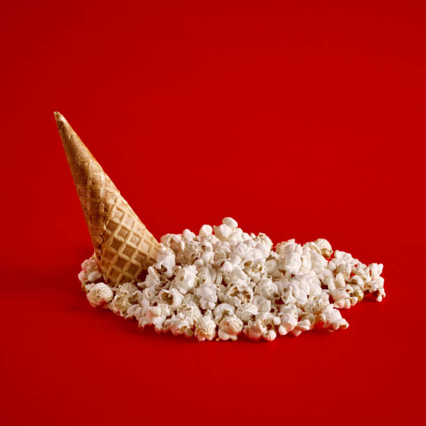 istock Upside down ice cream cone with spilled popcorn on red background. 1362489594
