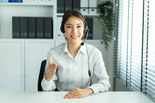 Asian beautiful woman video call with hr manager for job interview. Beautiful girl use laptop computer for virtual online conference discuss and show resume to office worker man to apply job for work. stock photo
