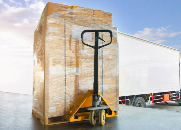 istock Packaging Boxes Wrapped Plastic Film on Pallets Loading into Shipping Cargo Container. Supply Chain. Trucks Parked Loading at Dock Warehouse. Shipment Logistics. Cargo Freight Truck Transport. 1362491252