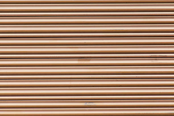 Real texture made of light brown rubber in the shape of diagonal stripes, illuminated with light.