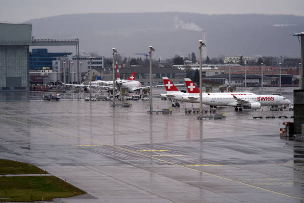 aéroport suisse zürich kloten avec fond de ciel nuageux. - runway airport sky wet photos et images de collection