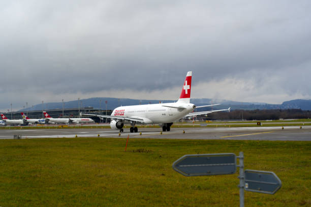 aéroport suisse zürich kloten avec fond de ciel nuageux. - runway airport sky wet photos et images de collection