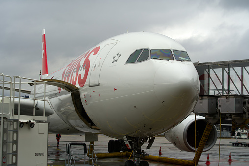 Close-up of Swiss airplane Airbus A330 register HB-JHJ with open cargo hatch at Zürich Airport on a rainy winter day. Photo taken December 26th, 2021, Zurich, Switzerland.