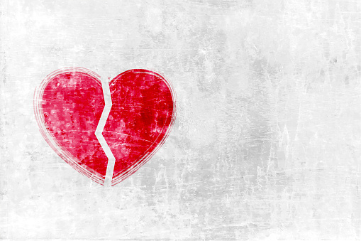 Horizontal vector illustration of light pastel grey coloured grungy wall textured blank empty vector backgrounds. There is ample copy space, no text and no people. There is one bright red broken heart in the left leaving space in the right. Apt for heart breaks, relationship break up, divorce, separation related backdrops or wallpapers.