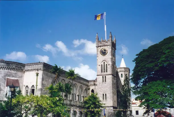 The national flag flying above the Clock Tower of the Parliament Building in Bridgetown, Barbados
