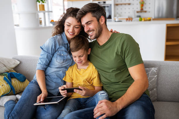 istock Happy family using technology devices together at home. 1362501202