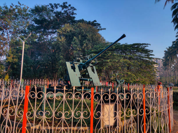 Stock photo of Bofors gun showcasing at Rankala lake garden , green tree and blue sky on background. Picture captured under bright sunlight at Kolhapur, Maharashtra, India. stock photo
