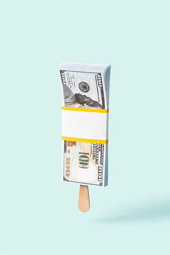 Concept of ice-cream with money. Dollars banknotes on light background