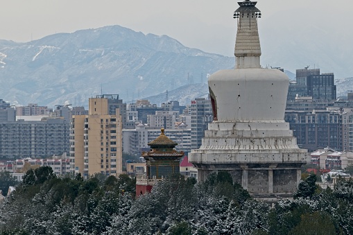 The stupa or great white pagoda was constructed during the Wanli reign of the Ming dynasty (1368–1644 AD), as recorded on a stone tablet there composed by the high minister Zhang Juzheng (1525–1582).[1]\nThe Sarira Stupa, named after the Sanskrit word sarira meaning 'Buddhist relic', sits on a square base with an archetypal sumeru pedestal. It is roughly 50 m (164 ft) tall, constructed of brick with a lime coating on the outside that gives its white color. The main upper frame of the stupa is shaped as an inverted bowl. The canopy of the stupa sits atop a steeple with thirteen tiers. The canopy and bead crowning the top are all made of gilded copper. The canopy also supports 252 small bells.