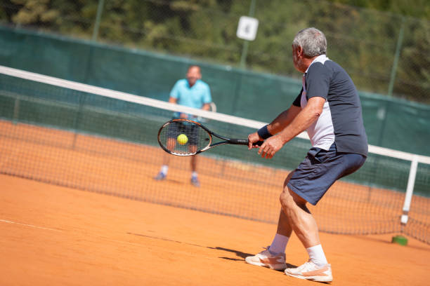 istock Men playing tennis on clay court 1362510316